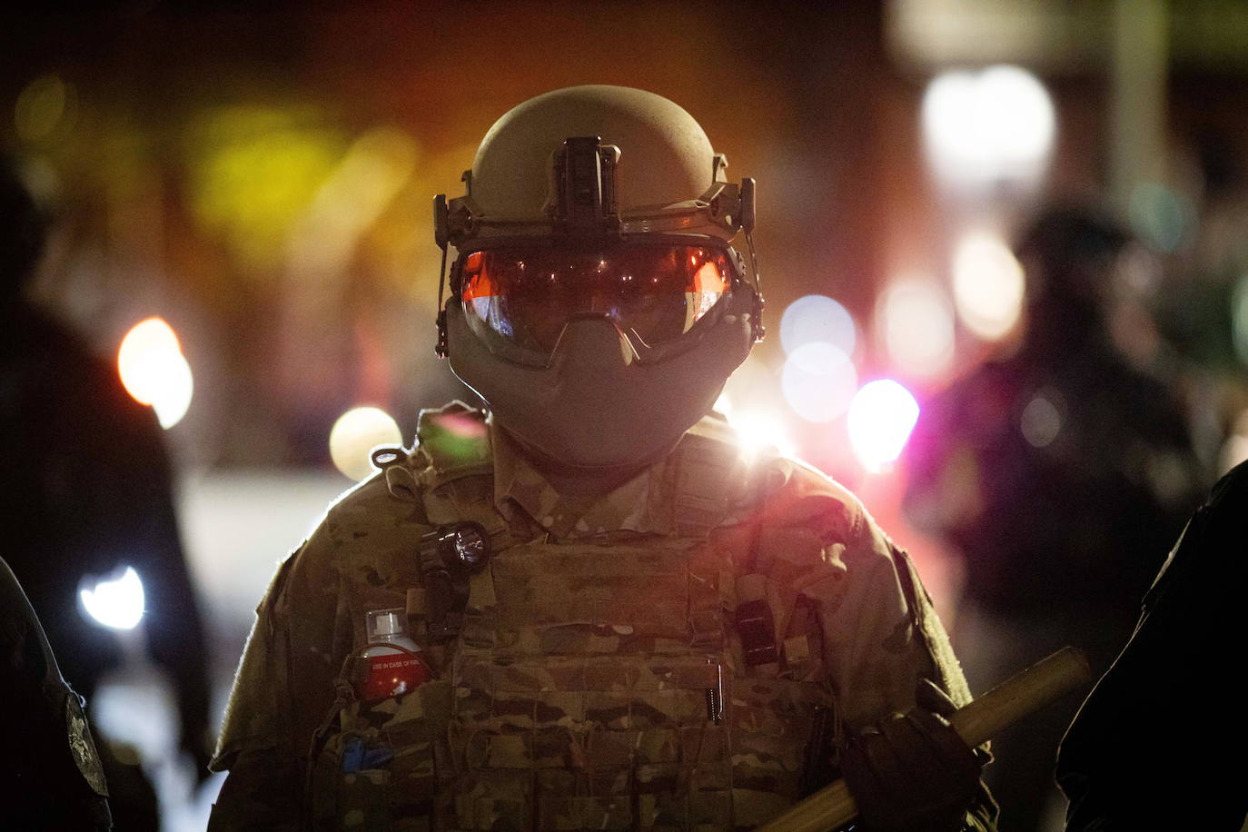 Un soldado de la Guardia Nacional sostiene un bastón mientras la policía intenta dispersar a los manifestantes antifascistas después de las elecciones presidenciales de EE. UU.