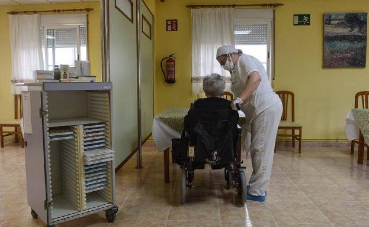 Una trabajadora de una residencia de Murcia atiende a una usuaria, en una fotografía de archivo. 