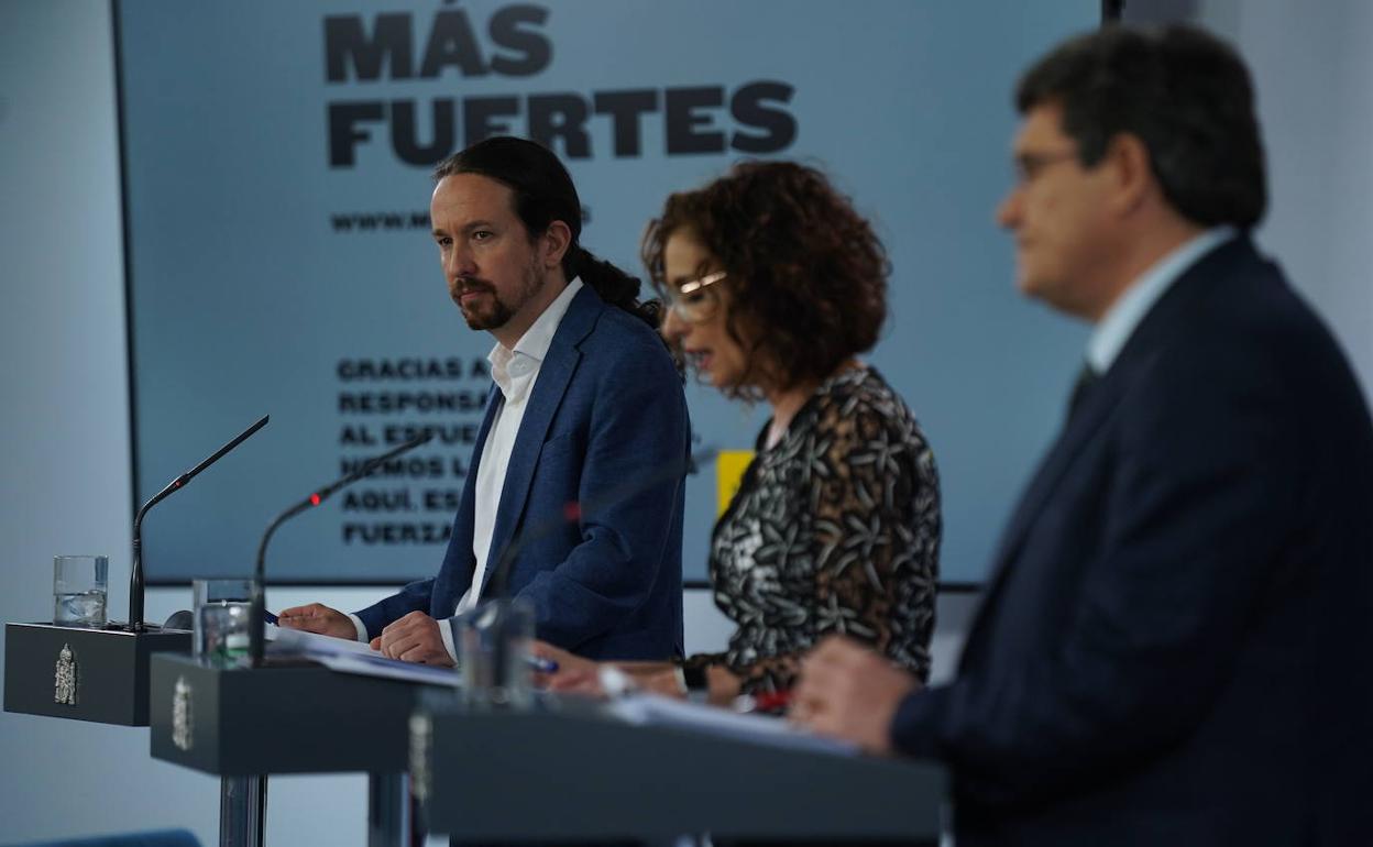 José Manuel Rodríguez Uribes (d), junto a la ministra de Hacienda, María Jesúss Montero (c), y el vicepresidente segundo, Pablo Iglesias. 