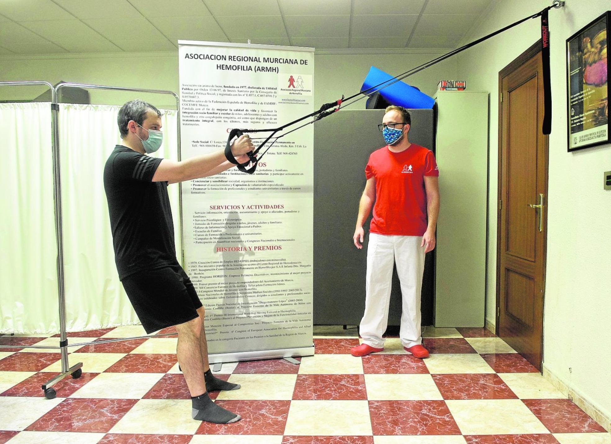 Un usuario realiza ejercicios con el fisioterapeuta del centro en Hemofiliamur. 