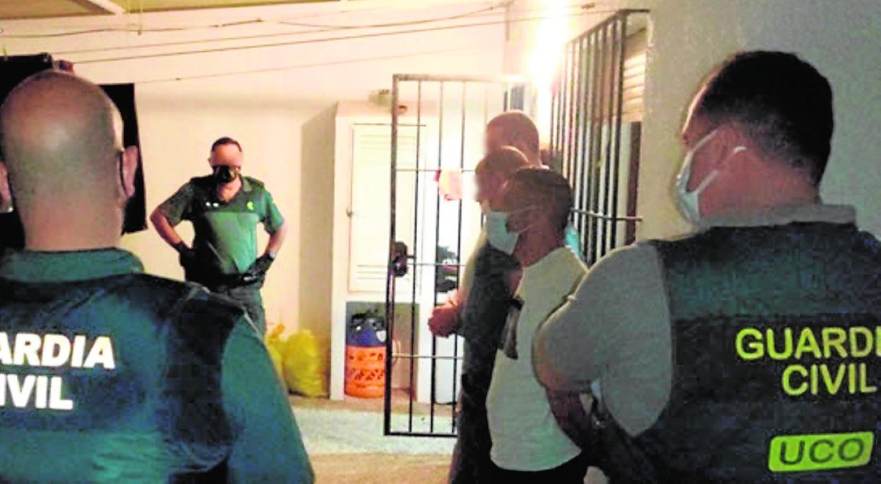 Agentes de la Unidad Central Operativa de la Guardia Civil custodian a los cuatro arrestados. 