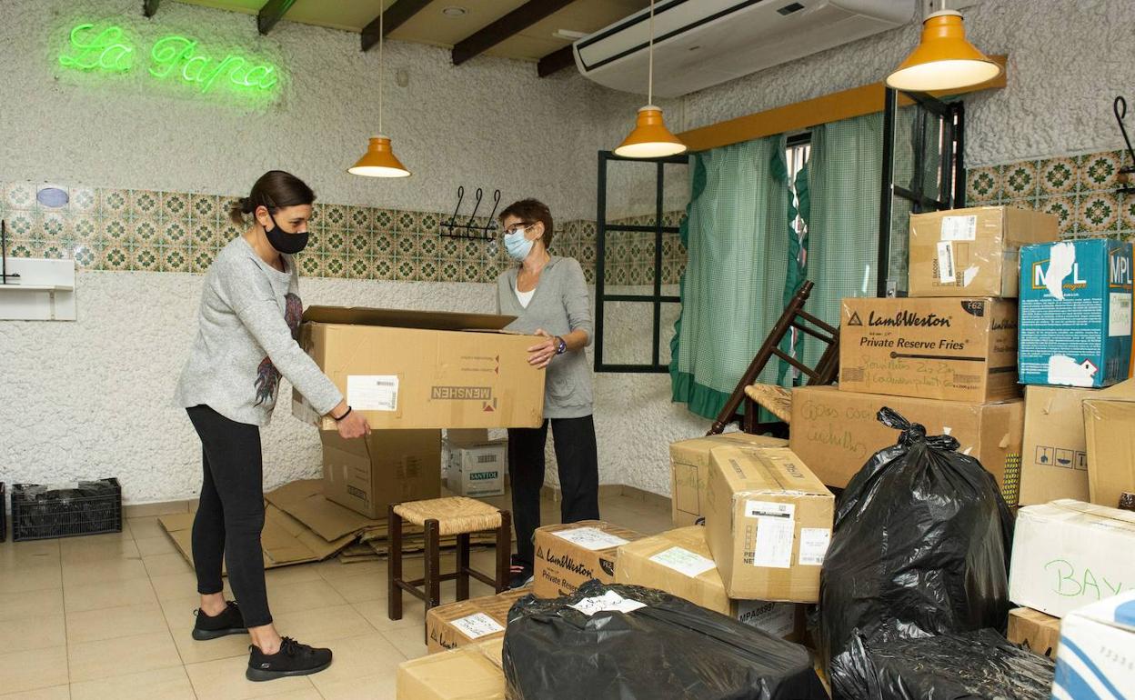 Pepa Cayuela y su hija Cristina guardan en cajas el material el local, este viernes.