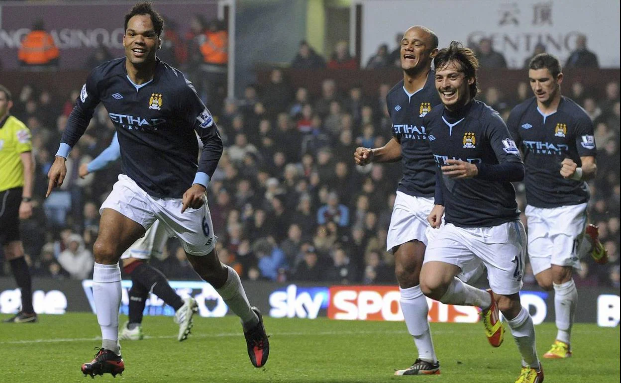 Lescott, con la camiseta del Manchester City, celebrando un gol perseguido por varios compañeros.