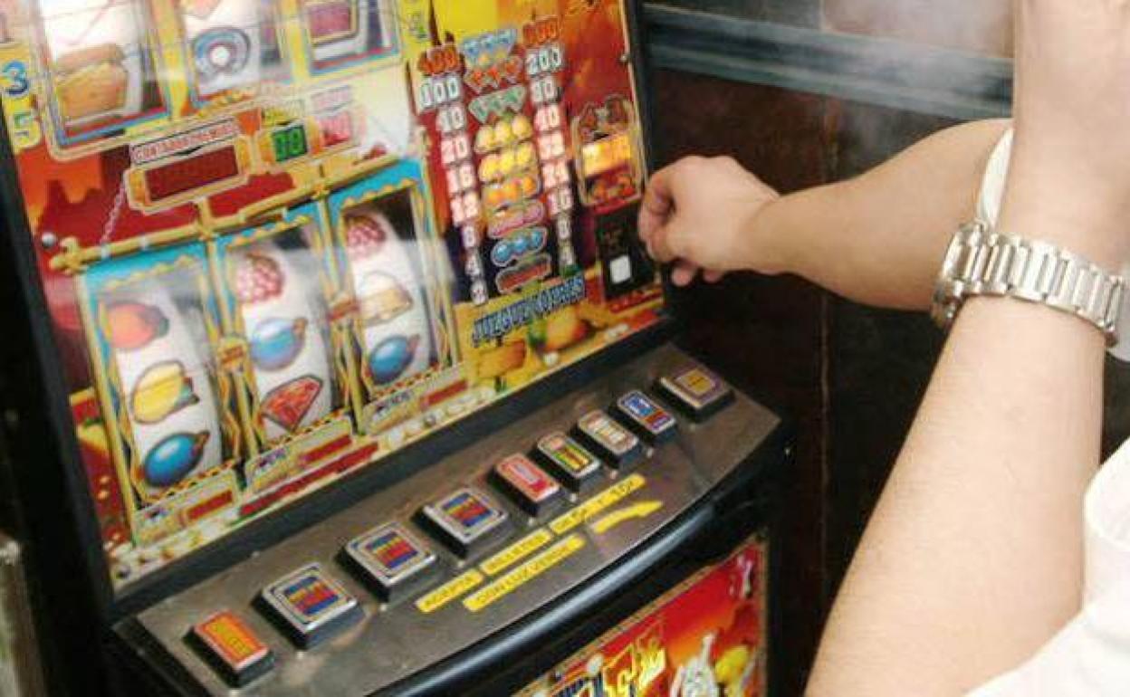 Un hombre juega a las tragaperras. 