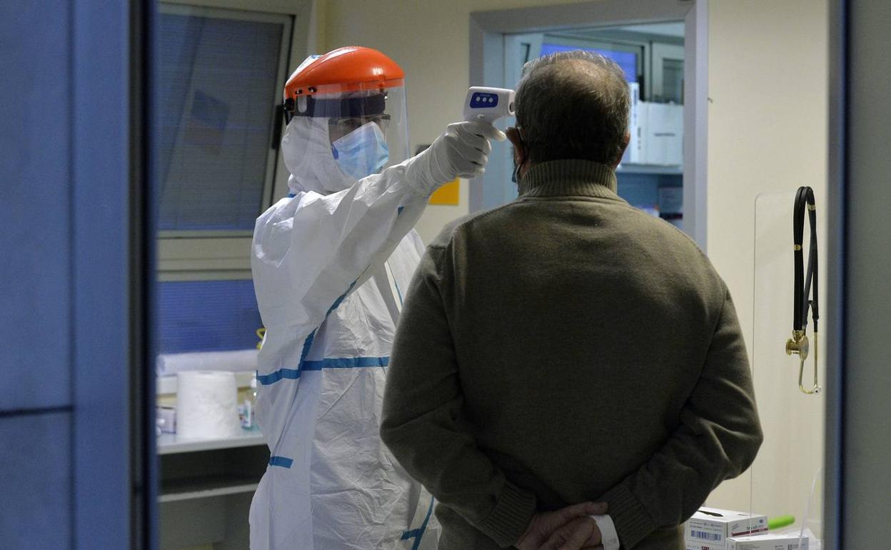 Un sanitario toma la temperatura de un paciente en el Reina Sofía en una imagen de archivo. 