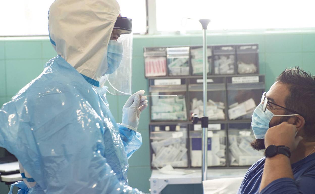 Un sanitario realiza una prueba de antígenos a un hombre, en una imagen de archivo.