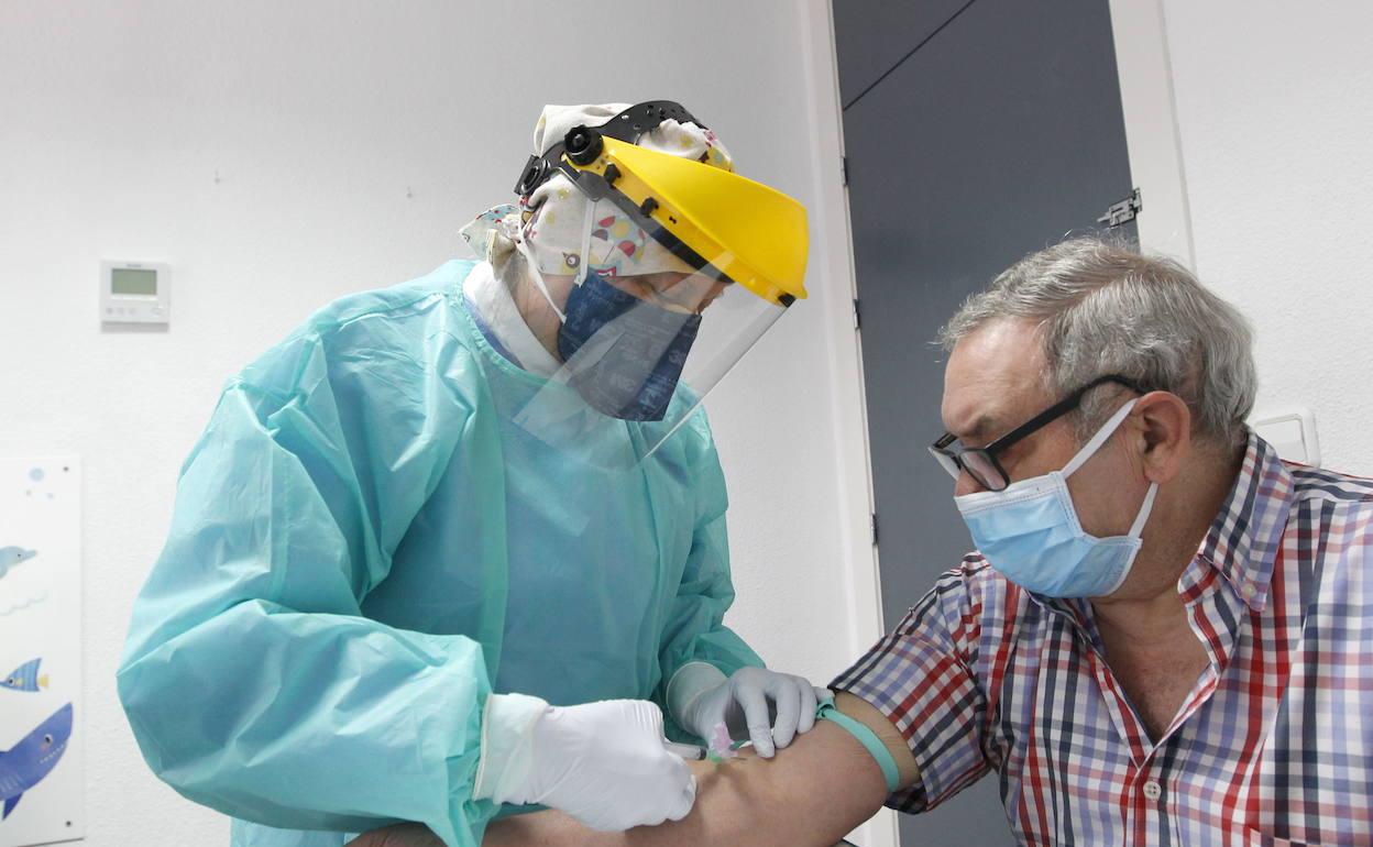 Una sanitaria toma una muestra de sangre de un paciente para un test serológico 