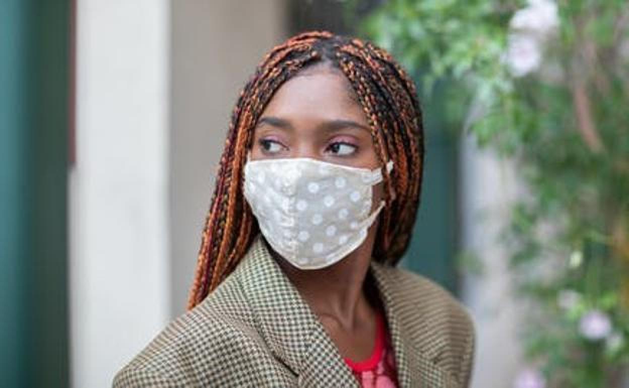 Una mujer con una mascarilla de tela.