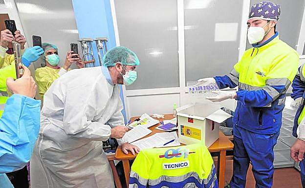 Imagen principal - Jaime Pérez, portavoz del Comité de Seguimiento Covid y receptor del pequeño gran cargamento de vacunas, comprueba el envío recibido en la residencia de mayores de San Pedro; la enfermera Sonia Caravaca suministra sus respectivas dosis a varios residentes del centro marmenorense, y uno de los viales de Pfizer que fueron administrados ayer.