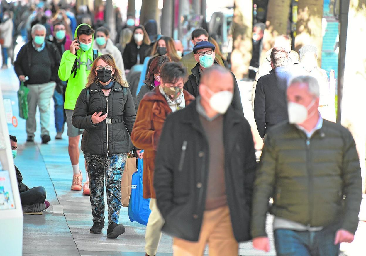 Peatones con bolsas y mascarillas caminan, ayer, por el centro de Murcia. 