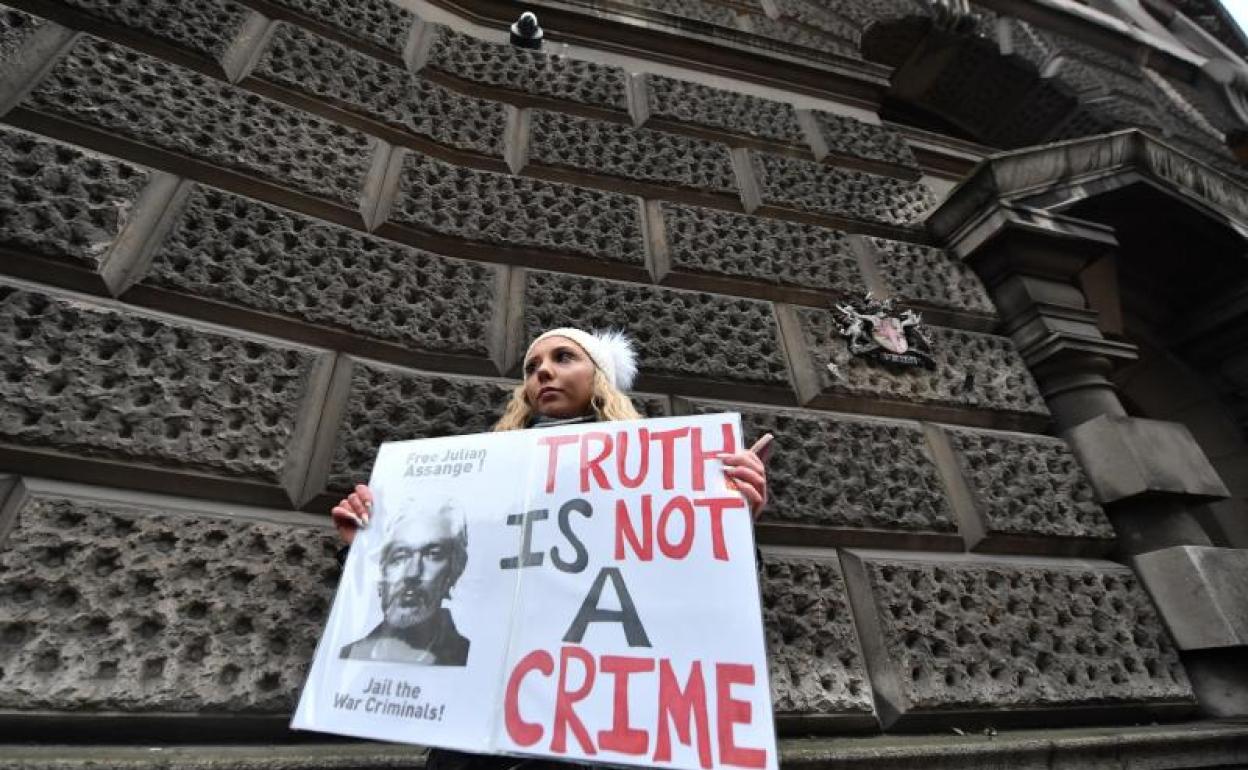 Una mujer sostiene una pancarta en apoyo a Julian Assange 