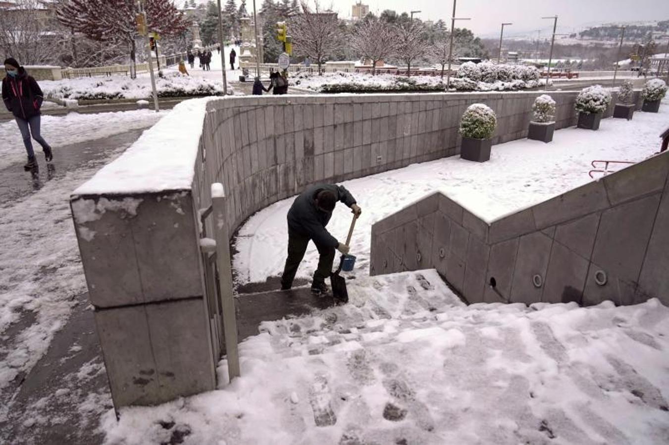 Un hombre quita la nieve helada de las escaleras en la ciudad de Teruel que sufre los efectos del temporal Filomena.