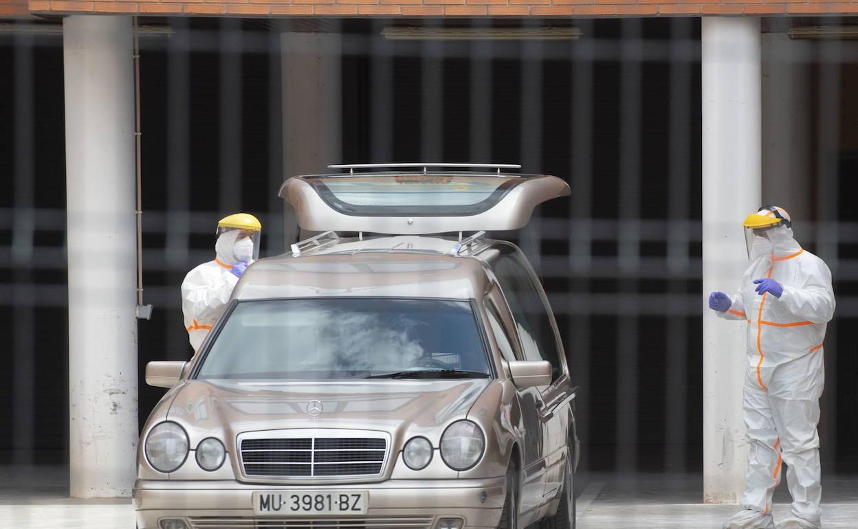 Dos sanitarios con equipos de protección, junto a un coche fúnebre, en la residencia Cáser de Santo Ángel, el pasado mes de abril, durante el primer brote que afectó al centro. 