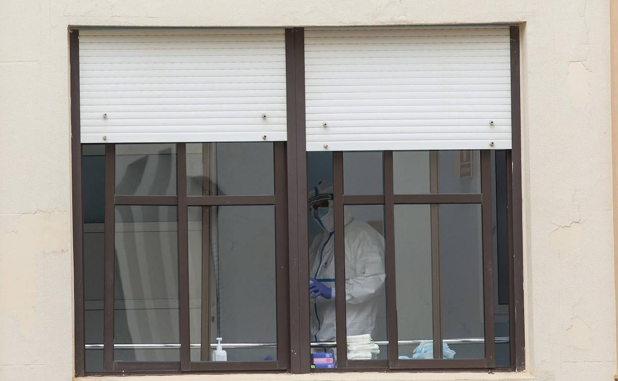 Un sanitario en una ventana del Hospital de Caridad de Cartagena, este domingo. 