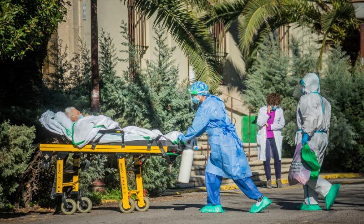 Sanitarios trasladan en camilla a un enfermo de covid-19 al Hospital Virgen de la Montaña de Cáceres, en Extremadura 