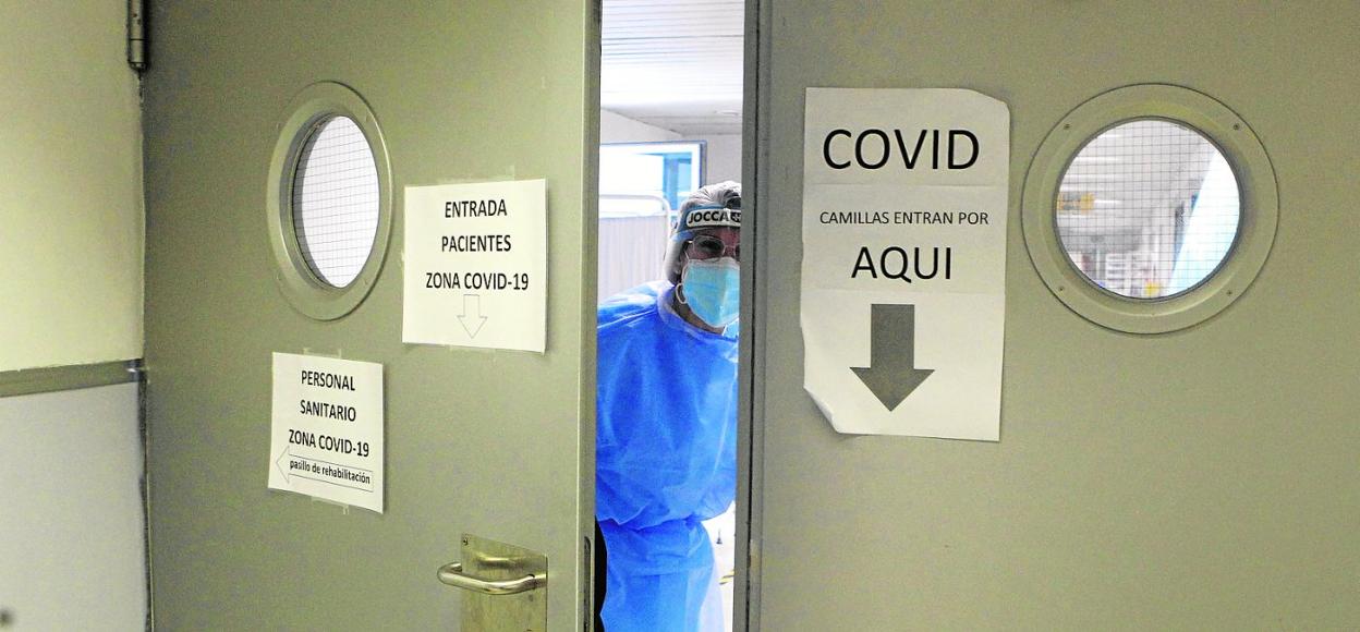 Una trabajadora del Reina Sofía cierra las puertas de una de las plantas del hospital destinadas a los pacientes de Covid-19. 