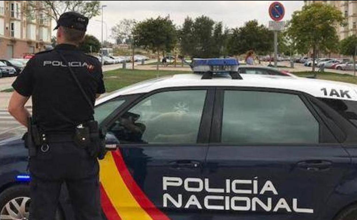 Un agente de la Policía Nacional junto a un vehículo del Cuerpo, en una fotografía de archivo.