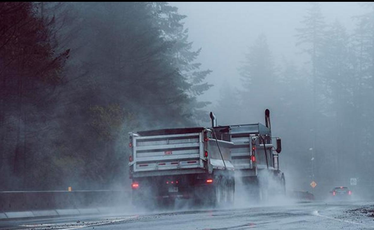 Vehículos circulando con lluvia.