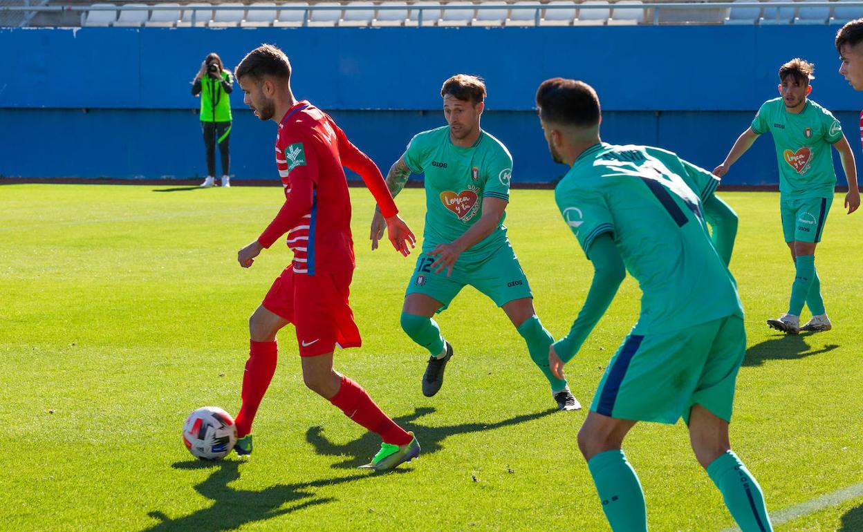 El centrocampista Britos, una de las bajas del Lorca Deportiva, persigue a un jugador del Granada B en un encuentro de esta temporada. 