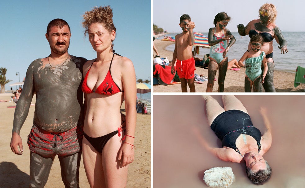 Una pareja de veraneantes posa para la cámara de Mar Sáez. Una familia cubierta de lodo en la playa de Lo Pagán. Una bañista descansa tumbada en la orilla del Mar Menor.