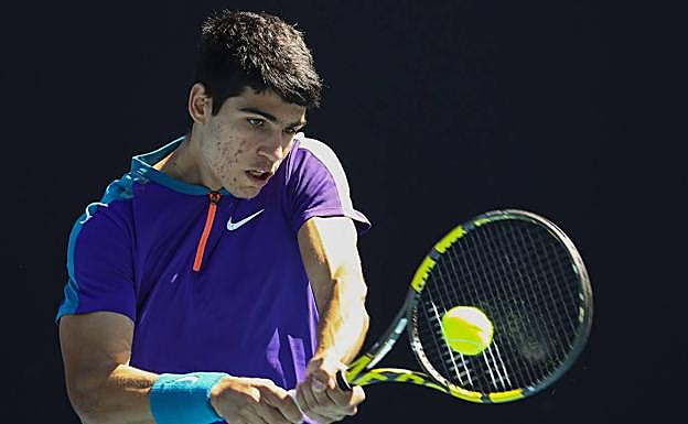 Alcaraz golpea una bola en su primer partido en un Grand Slam.