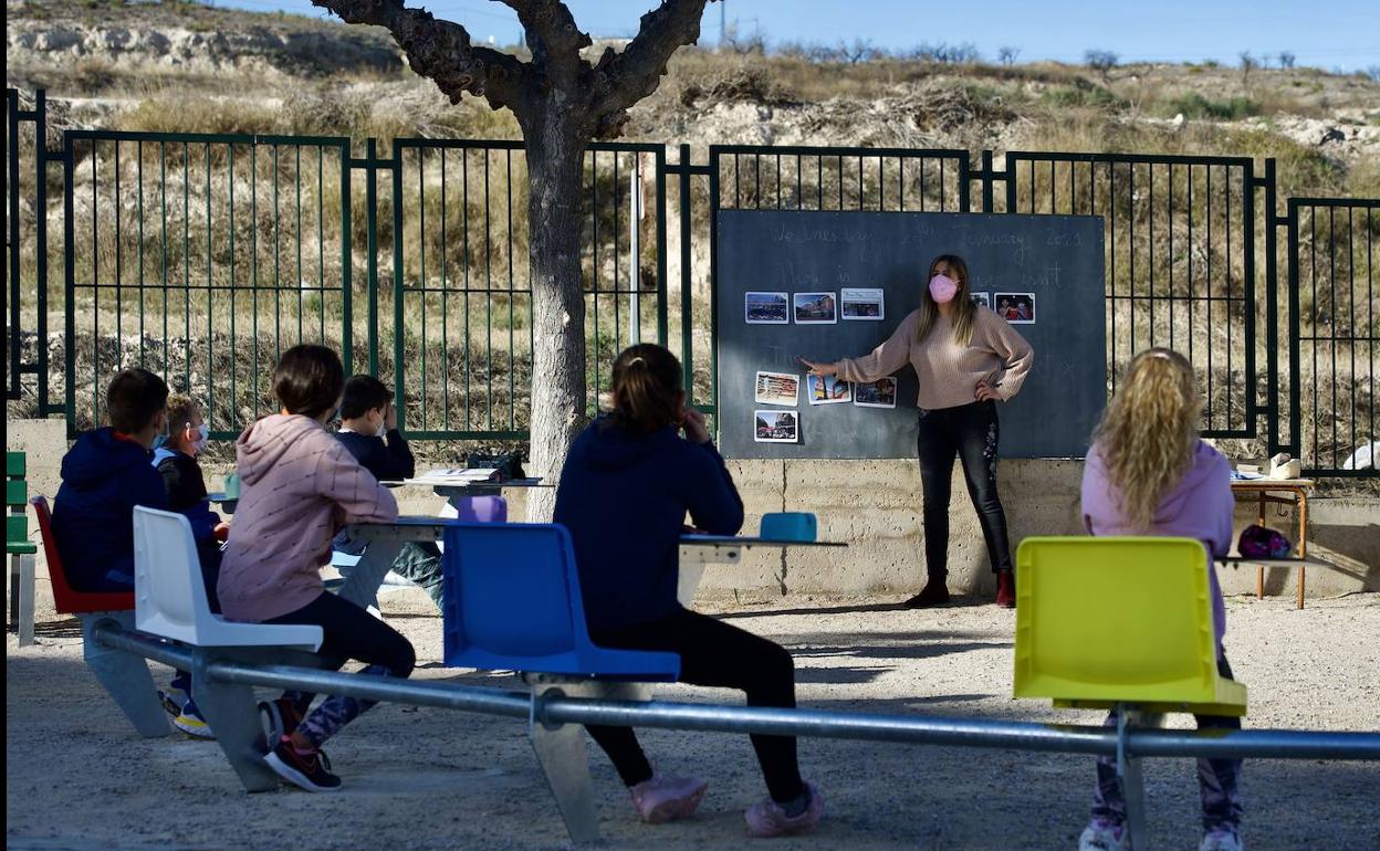 Niños sentados dando clase en un aula circular de metal en el patio del Colegio Martinez Chacas de Barqueros, Murcia, en una imagen de archivo.