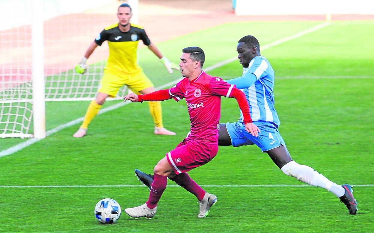 Doucoure, central del Lorca FC, intenta robar el balón a Cristo, del Racing Murcia, este domingo. 