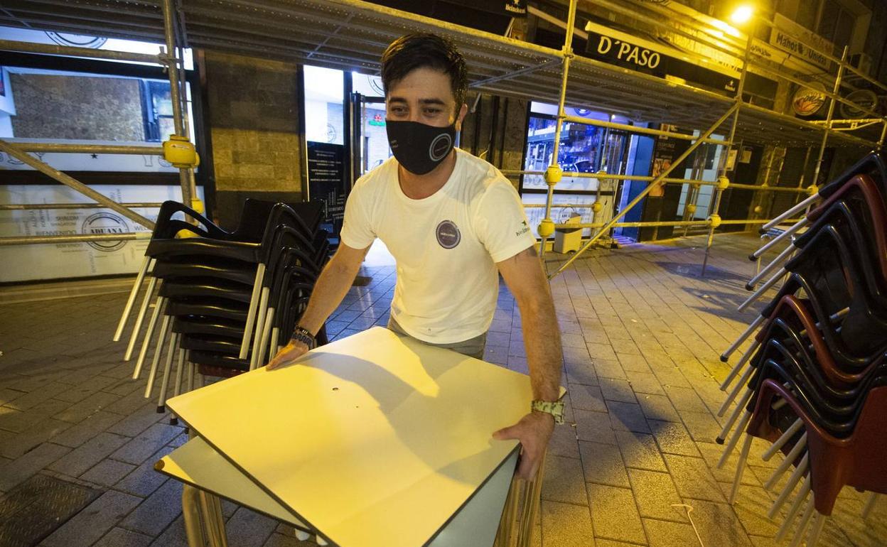 Un camarero recoge por última vez las mesas en una terraza de Murcia, en una imagen de archivo.