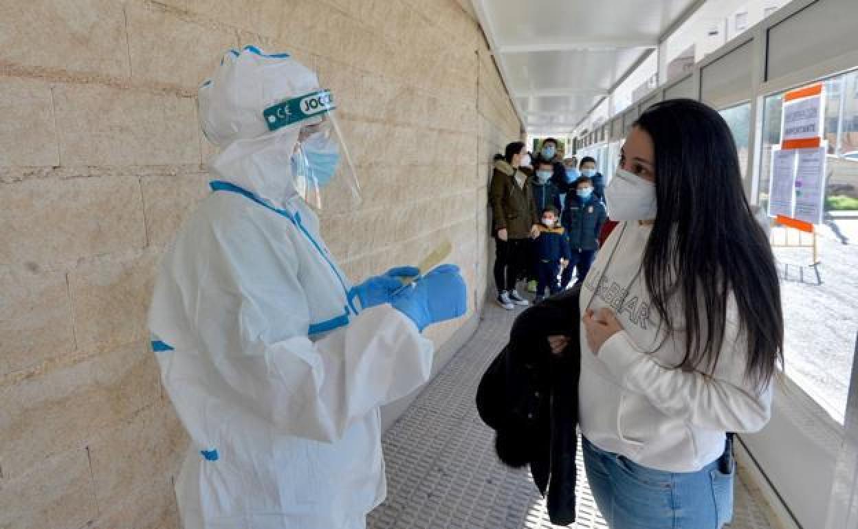 Un sanitario atiende a una mujer antes de realizarse una prueba de Covid, en una imagen de archivo.