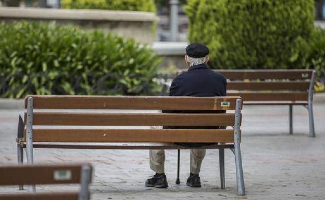 Un anciano sentado en un parque, en una imagen de archivo.