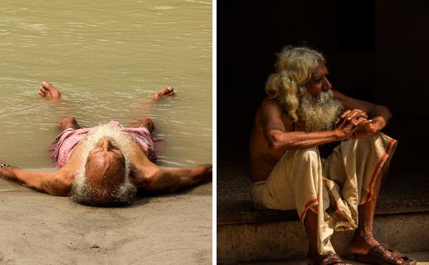 Un hombre sumerge pies y manos en las aguas del Ganges. Un sadhu o monje hindú descansa sobre unas escalinatas. 