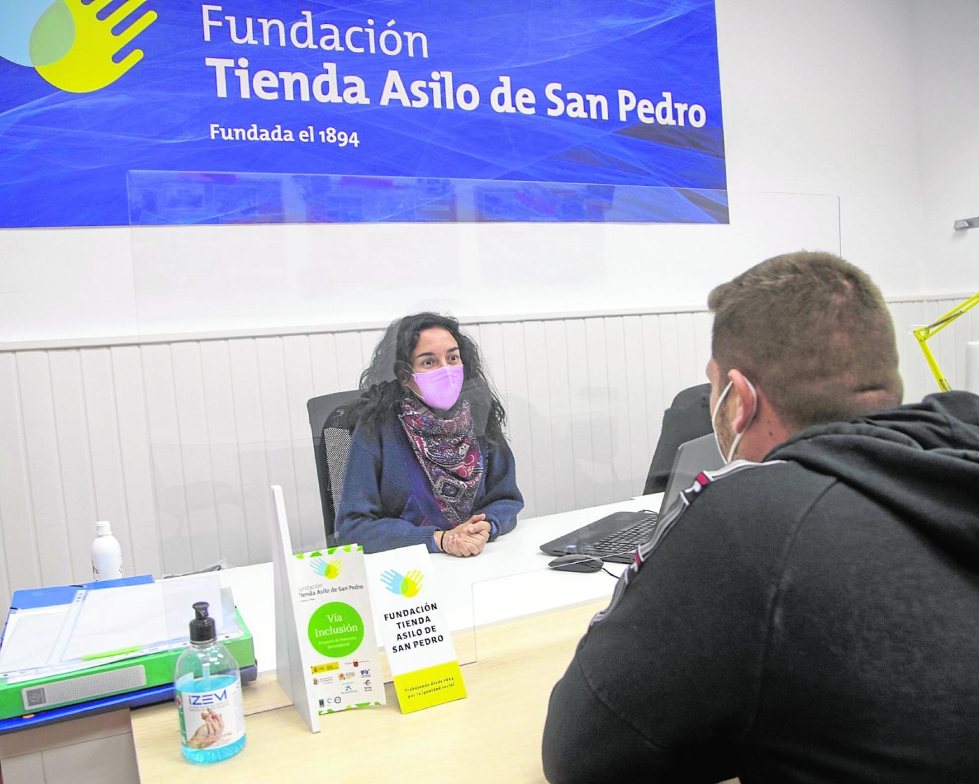 Una profesional de Fundación Tienda Asilo de San Pedro atiende a un usuario en sus instalaciones en Cartagena. 