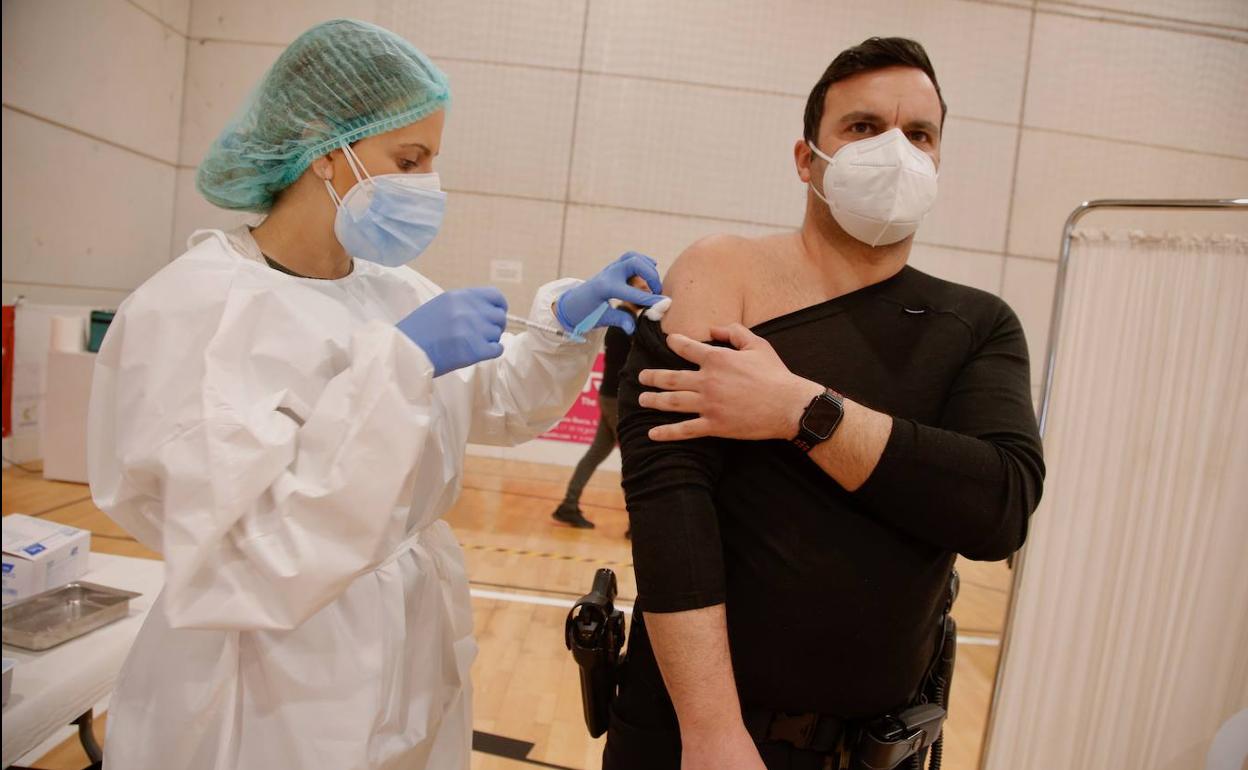 Un policía es vacunado contra la Covid -19 en el pabellón Cabezo Beaza de Cartagena, este martes. 