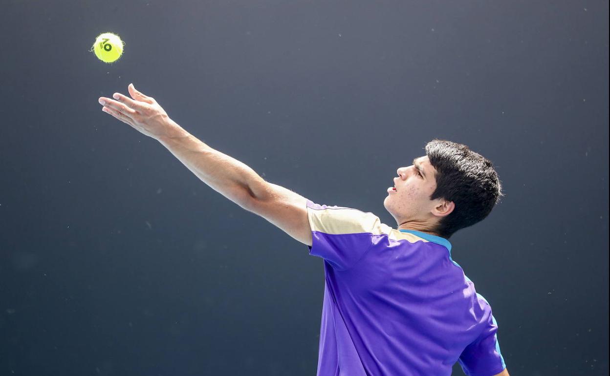 Carlos Alcaraz lanza la bola para sacar en el partido del Open de Australia ante Mikael Ymer.