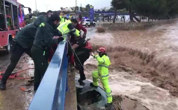 Los bomberos CEIS y los agentes de la Guardia Civil durante el rescate, este domingo en Águilas.