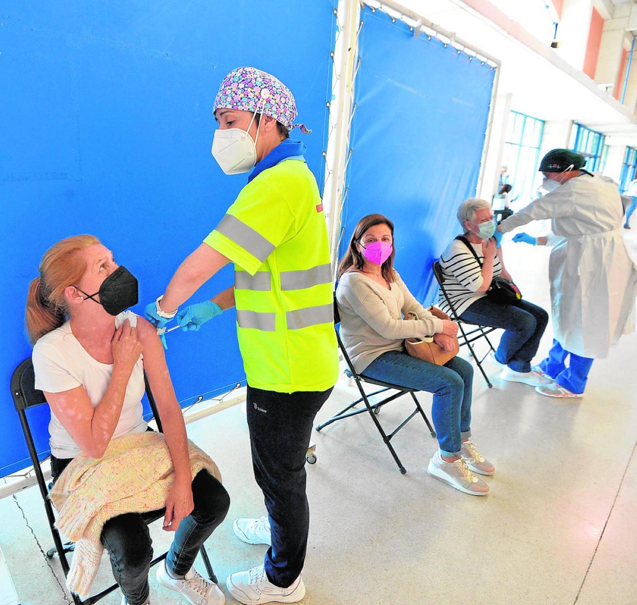 Varias mujeres de entre 63 y 65 años reciben la primera dosis de la vacuna, ayer en Murcia. 