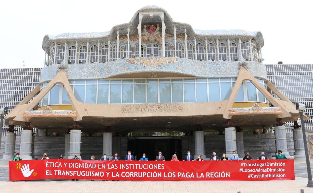 Los diputados de Cs se manifiestan con una pancarta a las puertas de la Asamblea. 