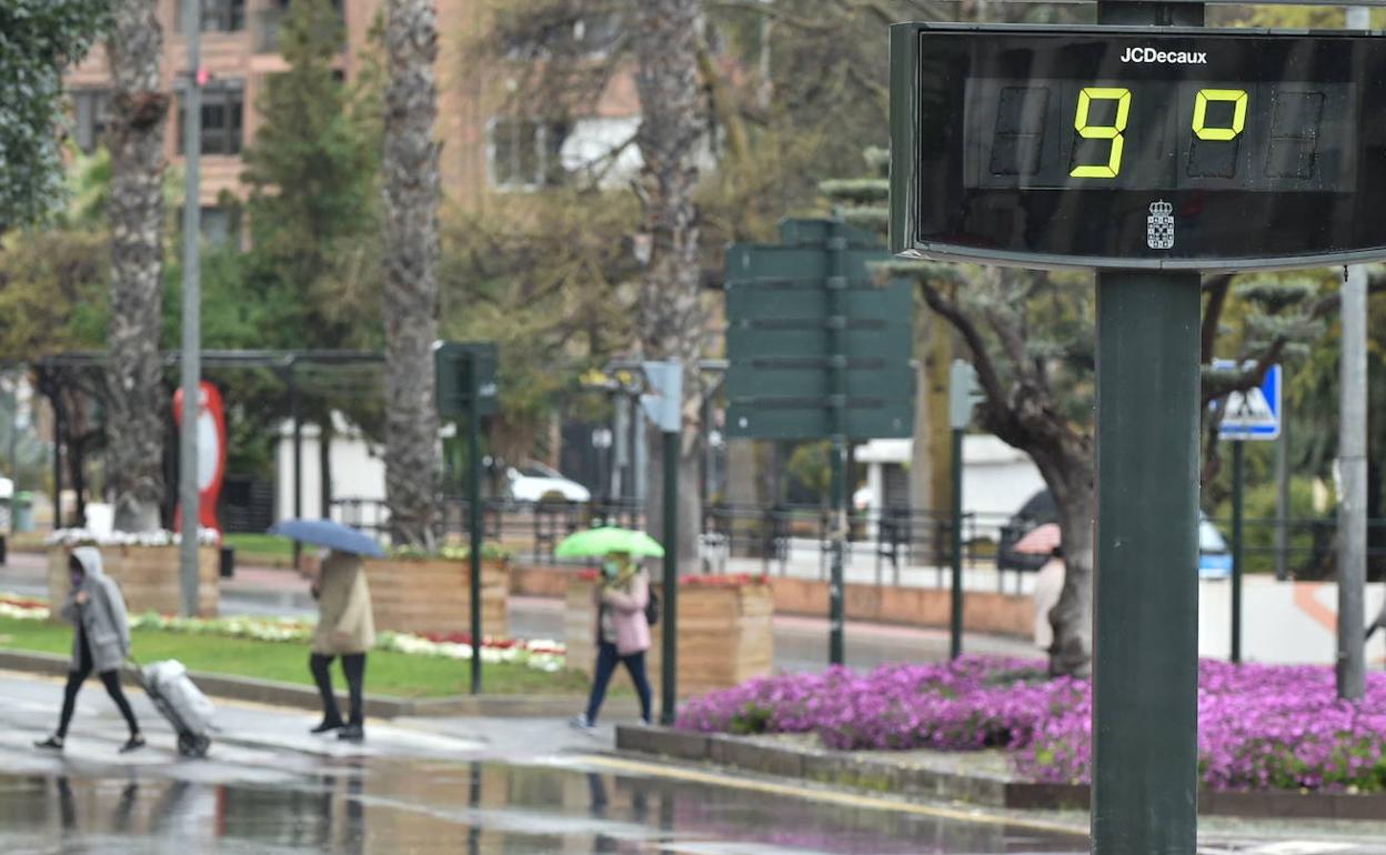 Varias personas protegiéndose de la lluvia con un paraguas en Murcia, en una imagen de archivo.