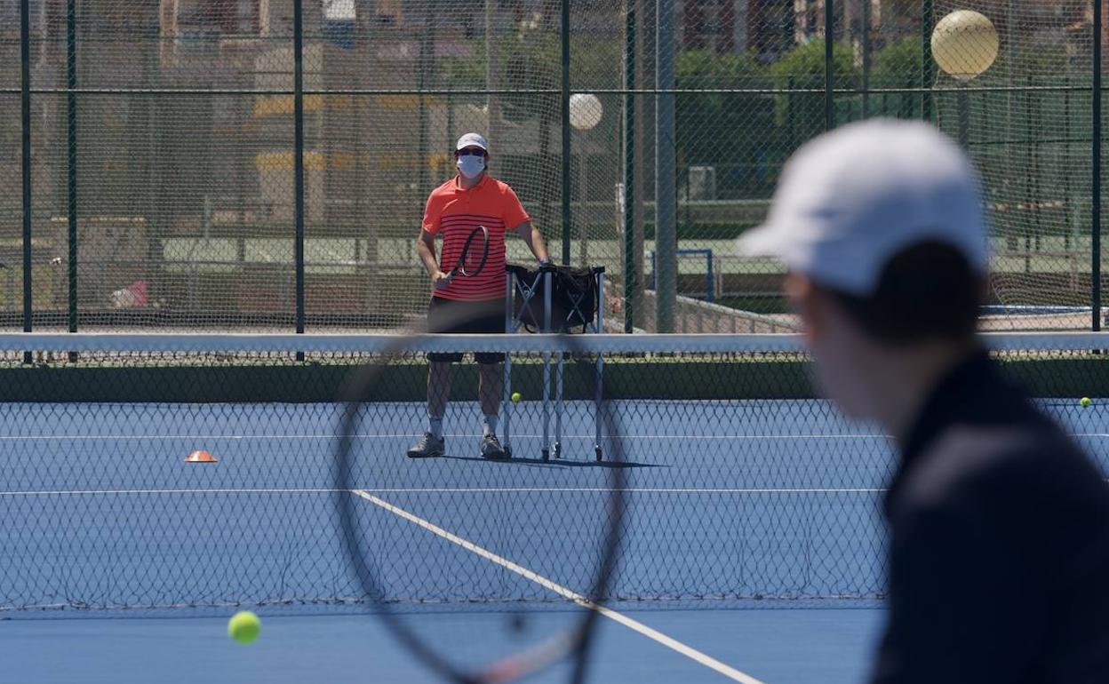 Dos chicos entrenan en unas pistas de tenis en Murcia, en una imagen de archivo. 