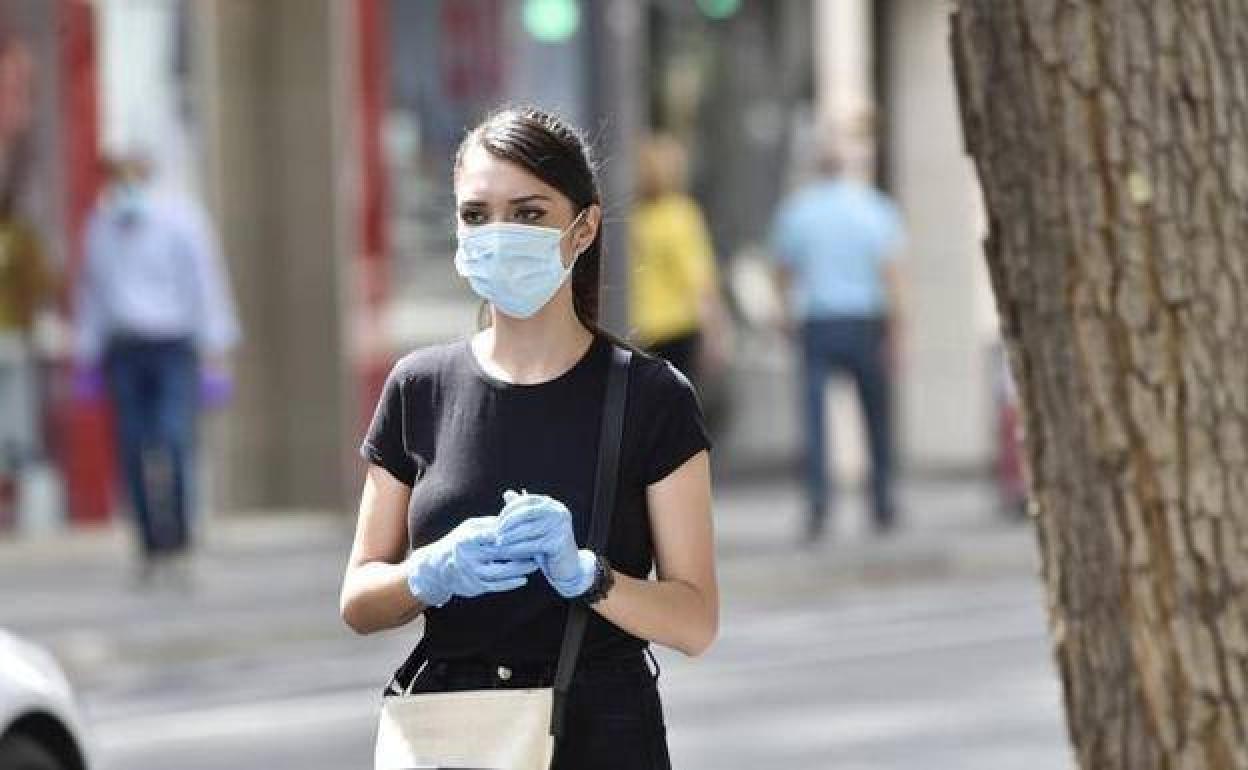 Una chica camina con mascarilla y guantes, en una imagen de archivo. 