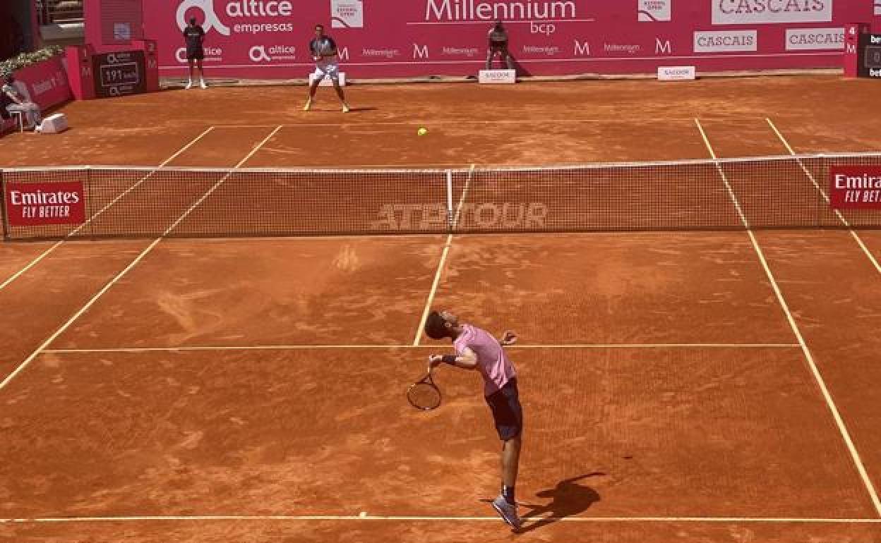 Carlos Alcaraz sirve, con Cilic al fondo, en el partido de este martes en Estoril.