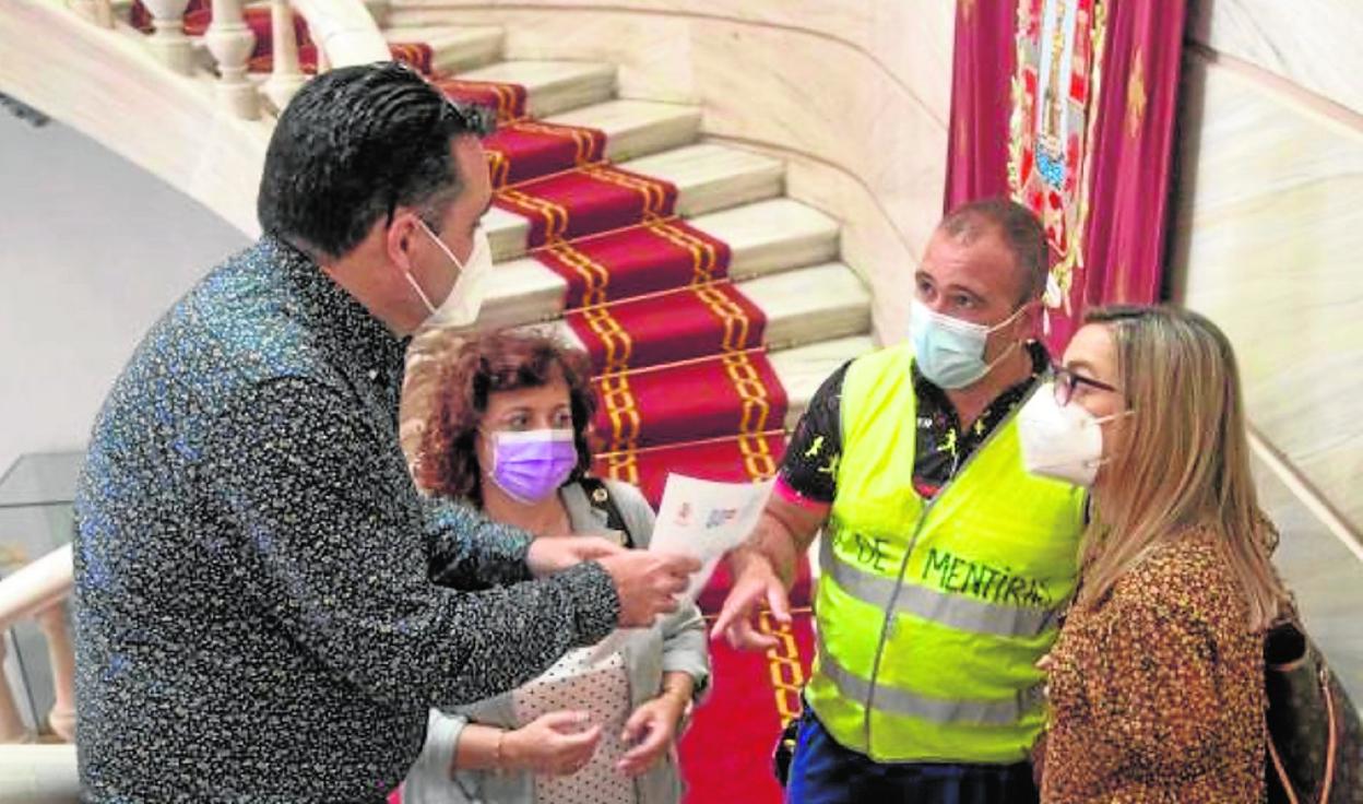 Un asesor de la alcaldía entrega el texto del acuerdo sobre el litoral al vocal de los exempleados de FCC, en presencia de la representante de CC OO, María Fernández, y de la edil de Contratación, María Amoraga. 