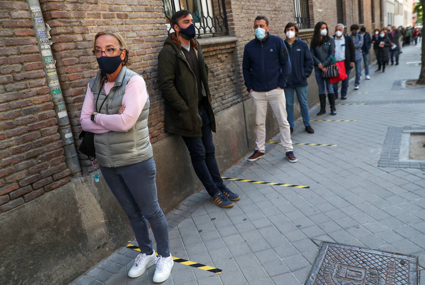 Largas colas a primera hora de la mañana en el exterior de uno de los colegios electorales. La gran afluencia y la distancia de seguridad hace que las filas sean frecuentes en todos los centros de votación. 