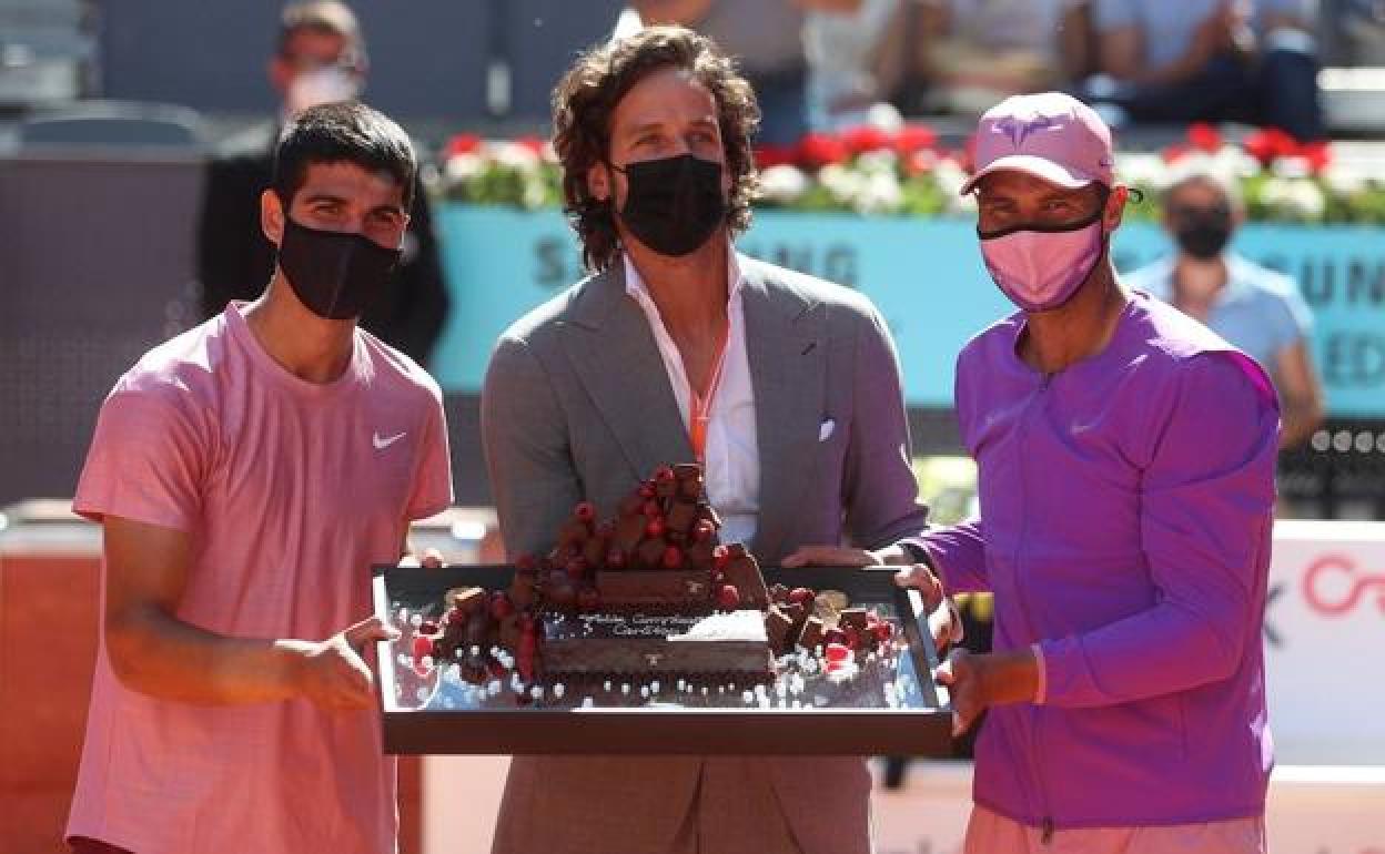 Carlos Alcaraz, Feliciano López y Rafa Nadal sostienen una tarta de cumpleaños para el murciano.