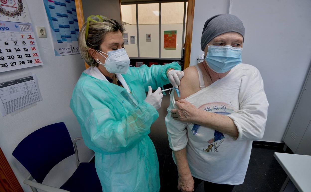 Una paciente oncológica recibe la primera dosis de la vacuna, ayer en el centro de salud de San Andrés, en Murcia.