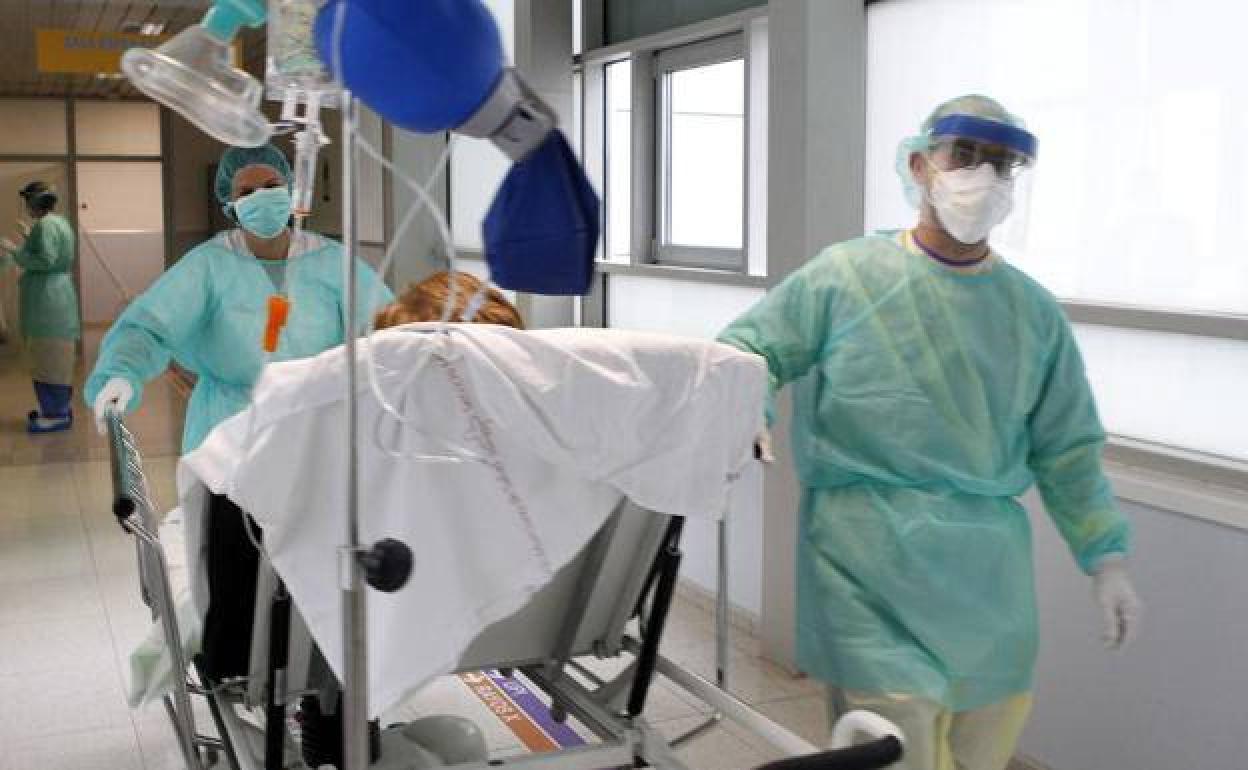 Dos sanitarios trasladan a una paciente en el hospital Reina Sofía, en una imagen de archivo.