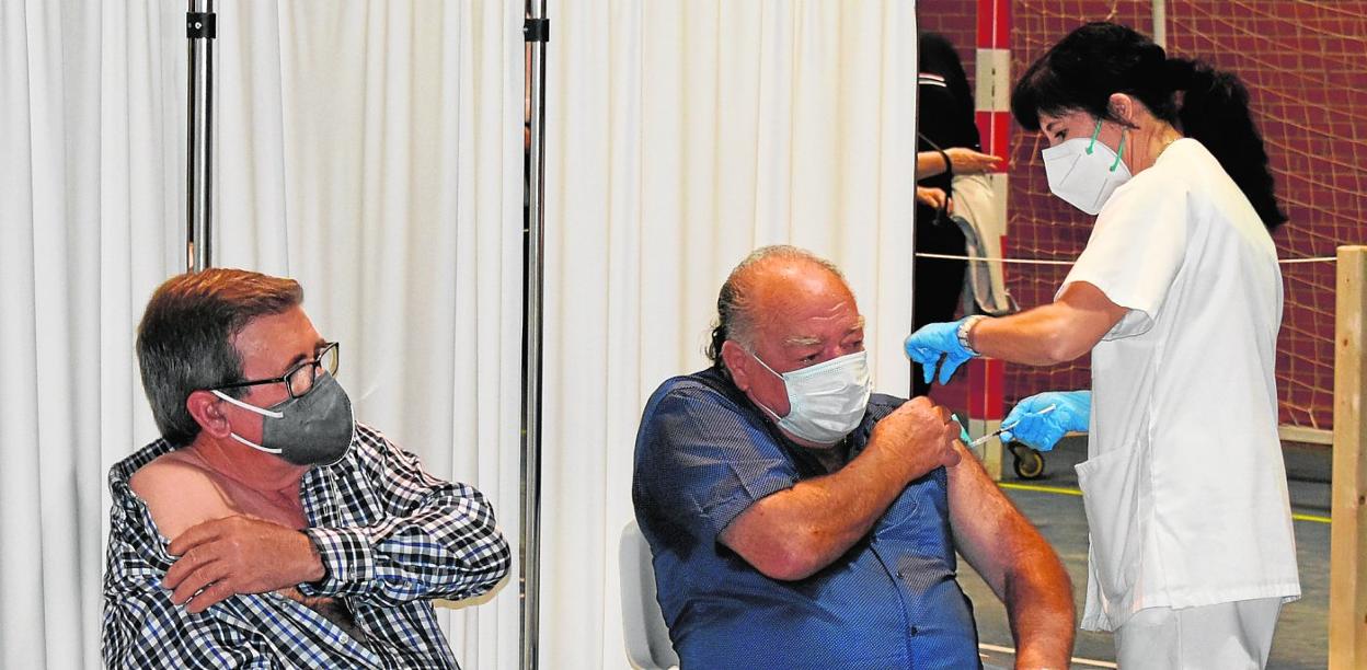 Una enfermera administra la vacuna a dos hombres en el pabellón Jorge Bera de Caravaca de la Cruz, ayer. 