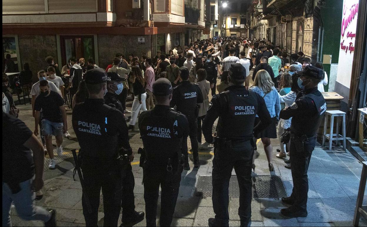 La Policía Local de Cartagena vigila el cierre de los bares a medianoche y dispersa los corrillos este sábado en la calle del Aire. 