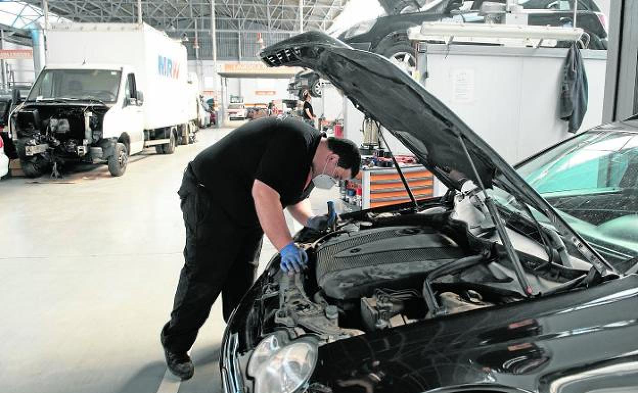 Un mecánico inspecciona un coche en un taller, en una imagen de archivo. 