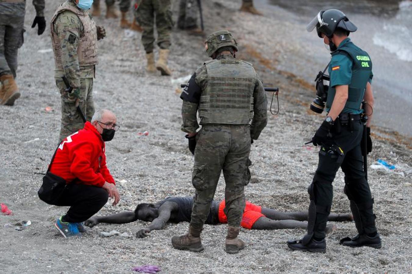 Un miembro de la Cruz Roja atiende a un hombre desfallecido.